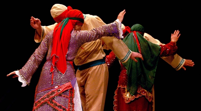 The cast of phantom of the opera dancing on the stairs on stage.